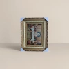 The golden carved photo frame is set with a religious brocade painting of the Last Supper, an arched window and a starry sky background Specification image
